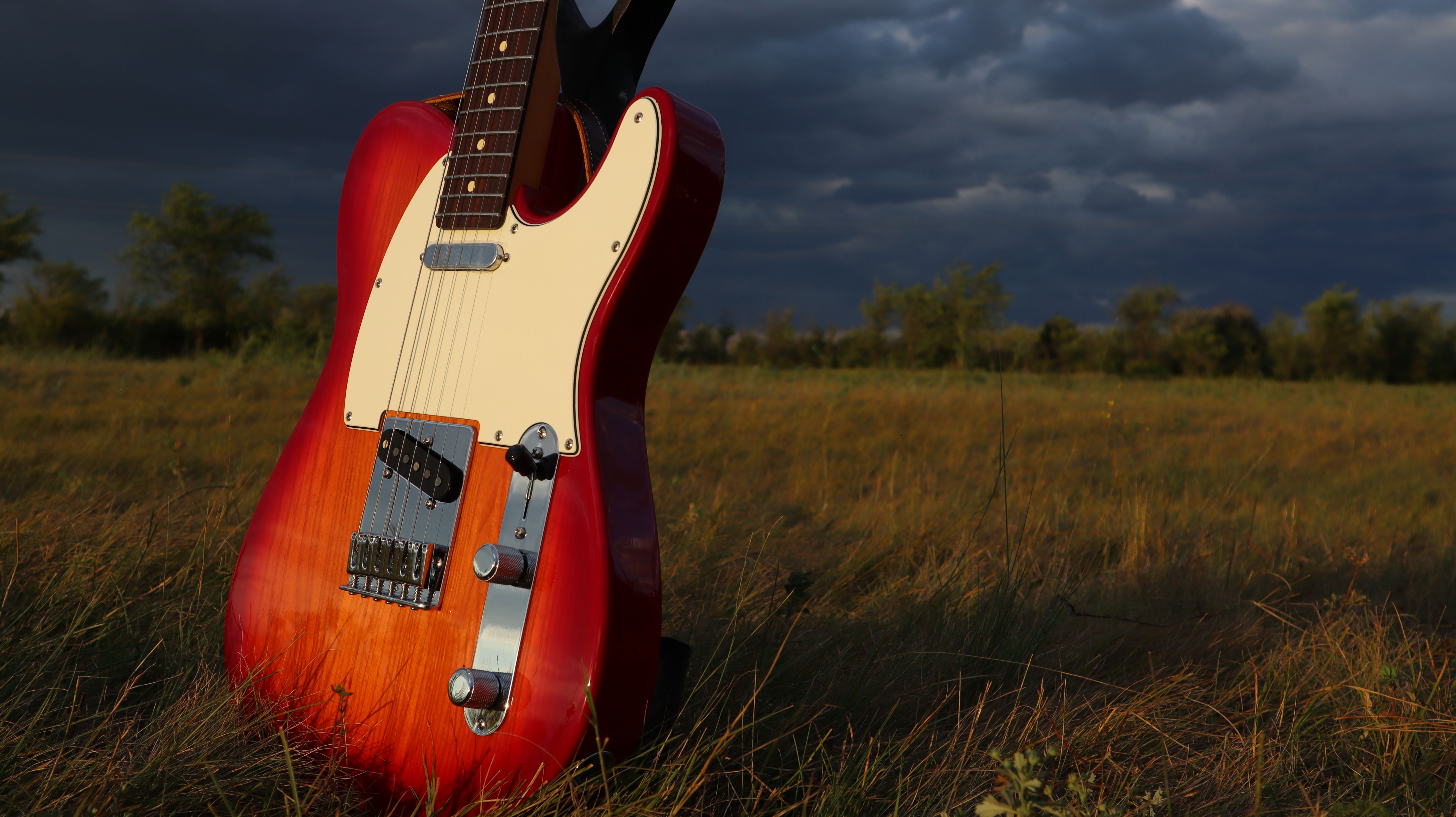 Vibrant Electric Guitar Outdoors in Sunset Field