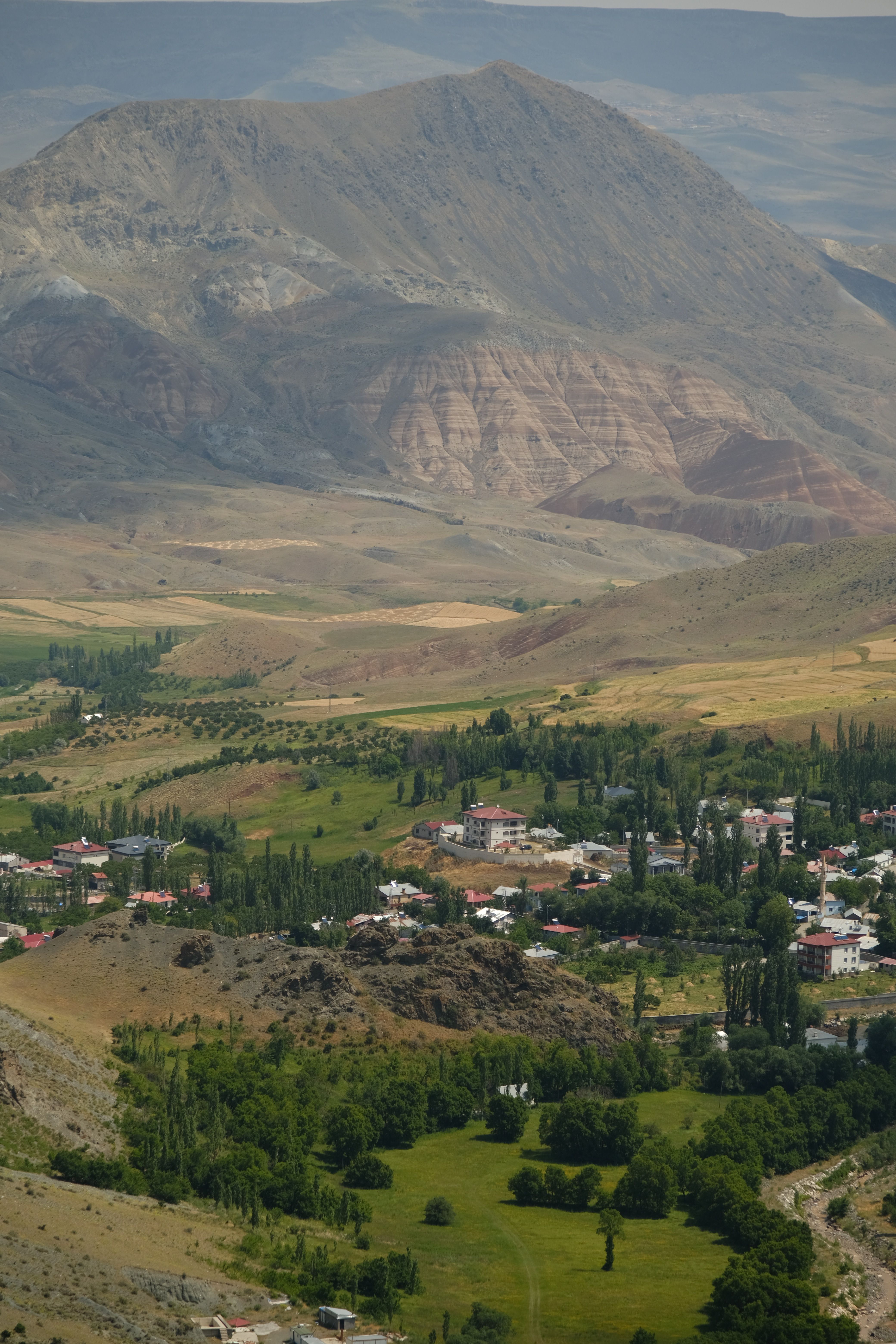 A picturesque village nestled in a lush green valley with majestic mountains.