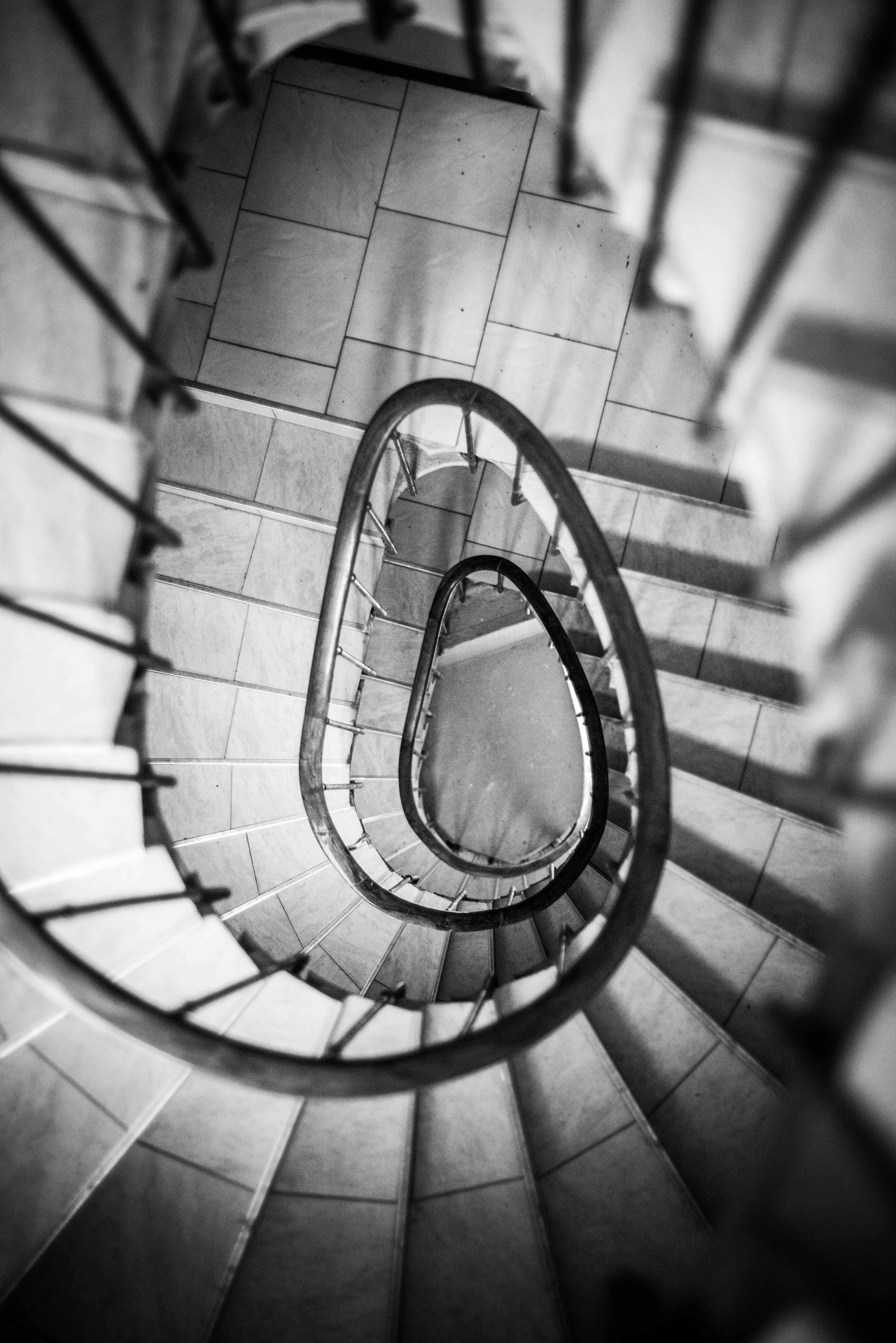 Artistic aerial shot of spiral staircase in monochrome tones.