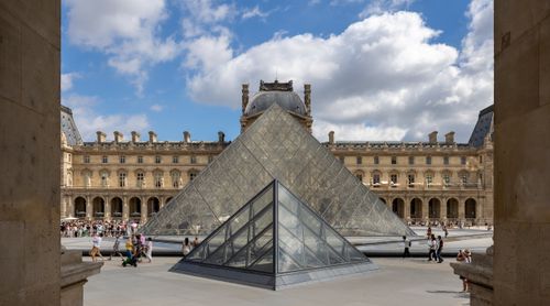 Free Explore the stunning glass pyramid at the Louvre Museum, Paris, on a sunny day. Stock Photo