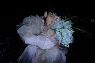 一位时尚人士在夜晚手持独特插花的创意肖像