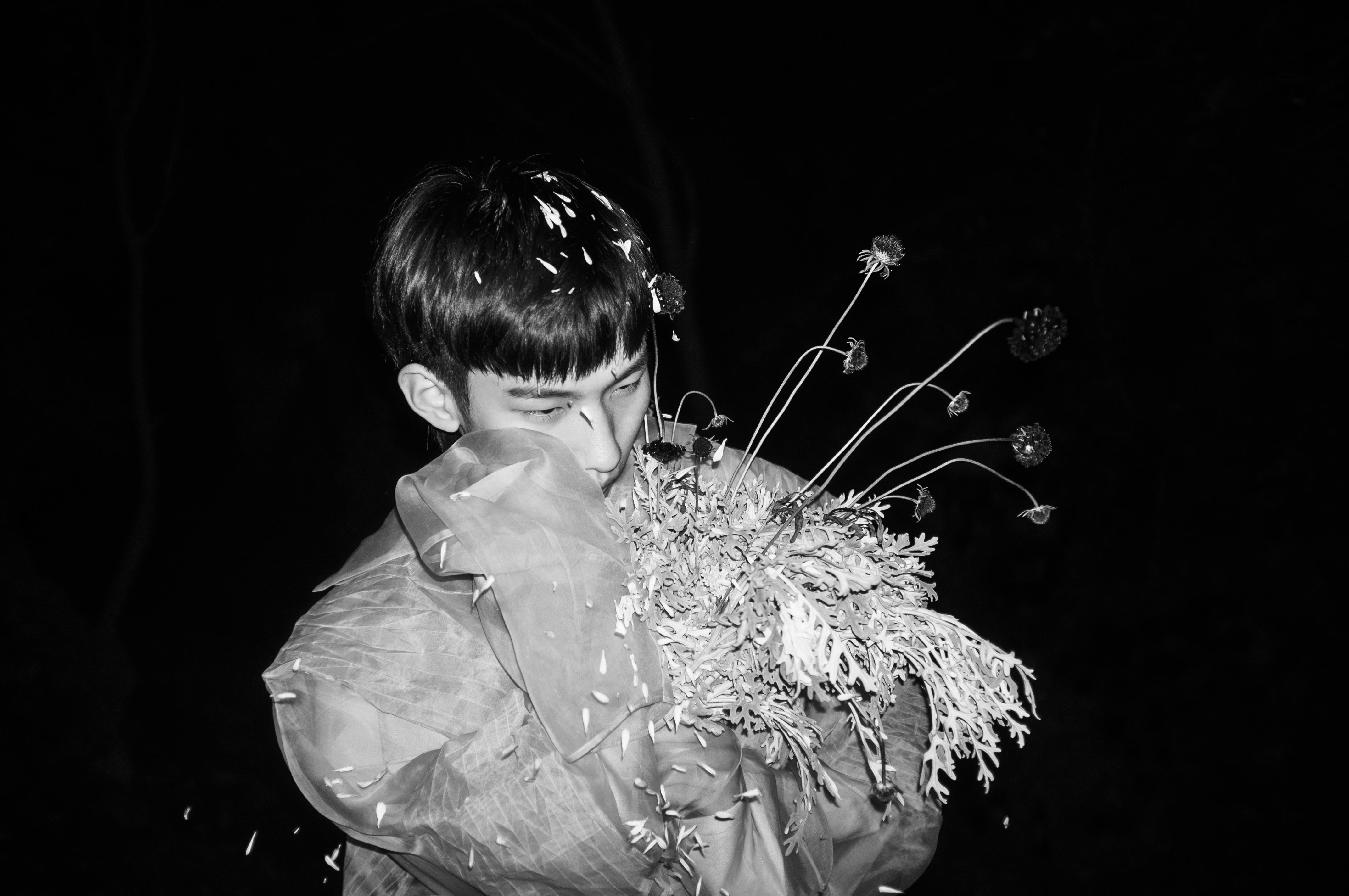 Grayscale Photo of Boy in White Dress Shirt Holding Flowers