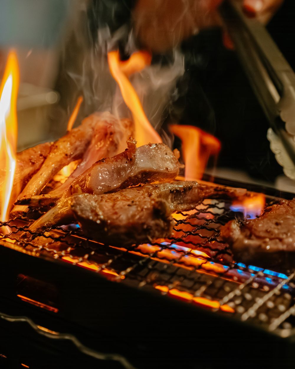 Juicy lamb chops sizzling on a flaming barbecue grill, capturing the essence of outdoor cooking.