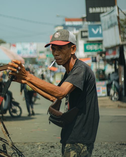 Free A street vendor managing goods at a bustling market in Banten, Indonesia, showcasing local culture. Stock Photo
