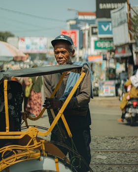 Elderly man with becak in a vibrant street market, Banten, Indonesia.