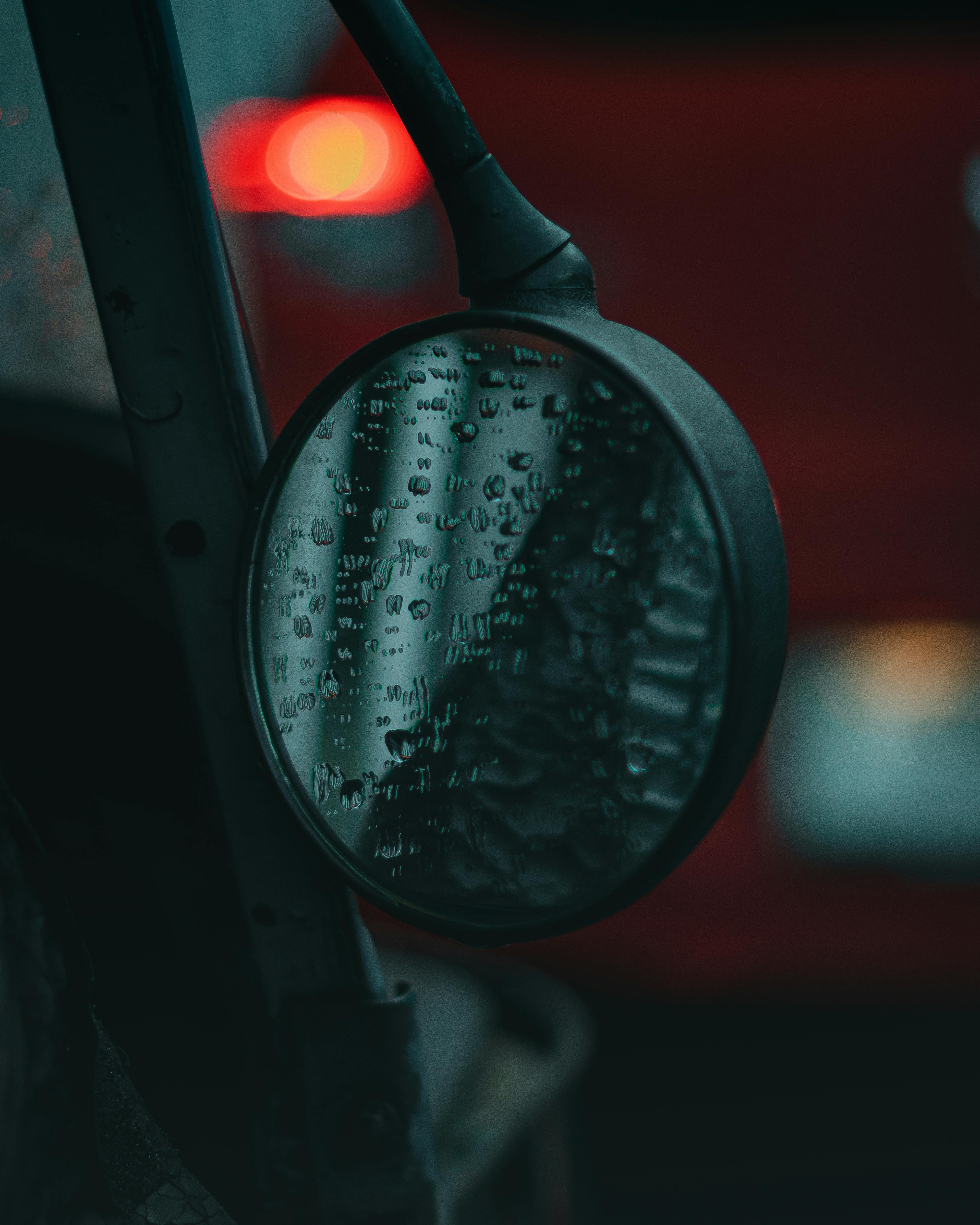 Gratis Tampilan dekat kaca spion samping yang terkena tetesan hujan memantulkan suasana perkotaan Jakarta di malam hari. Foto Stok