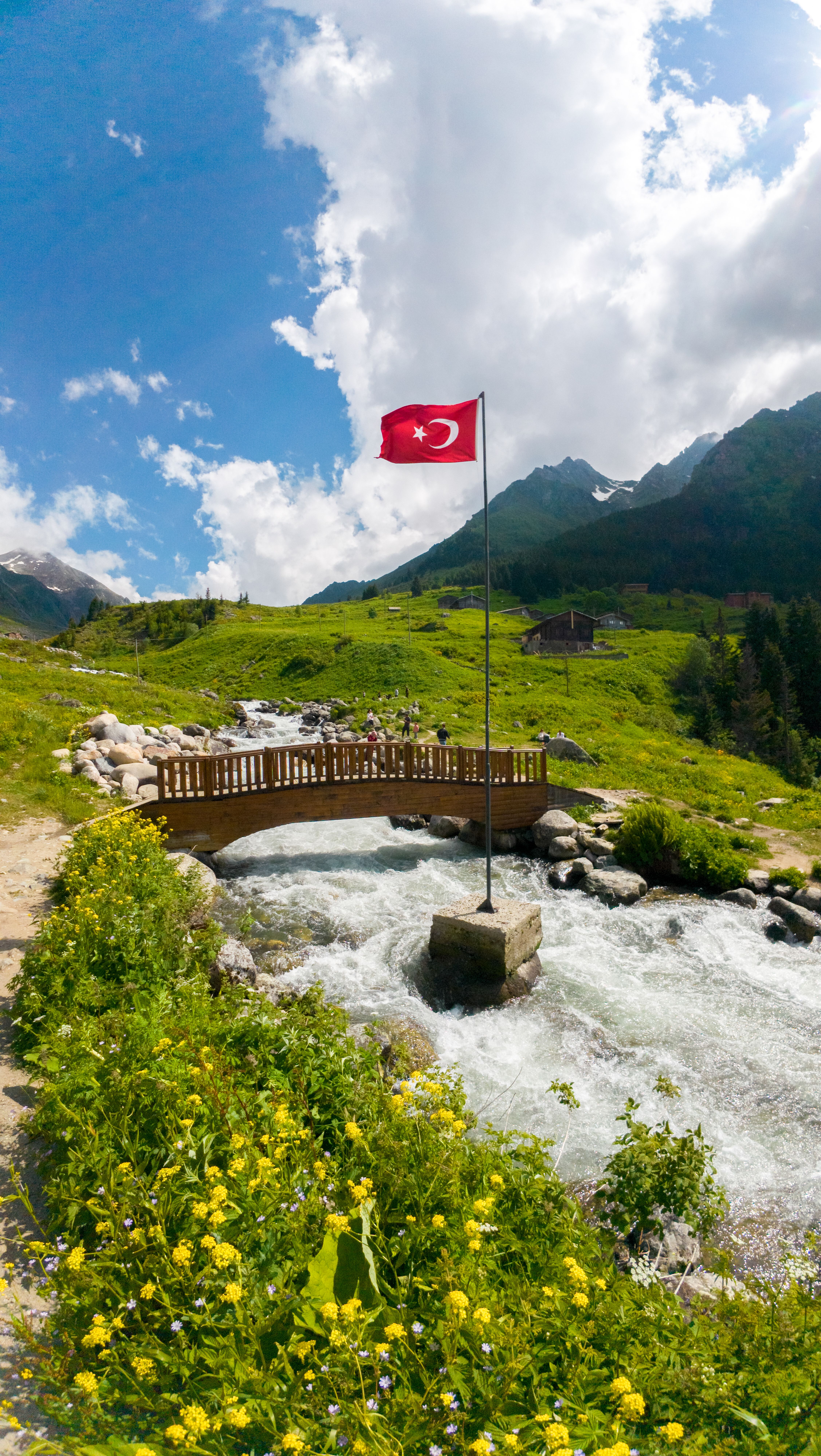 A picturesque Turkish landscape with mountain view, flowing river, and Turkish flag.