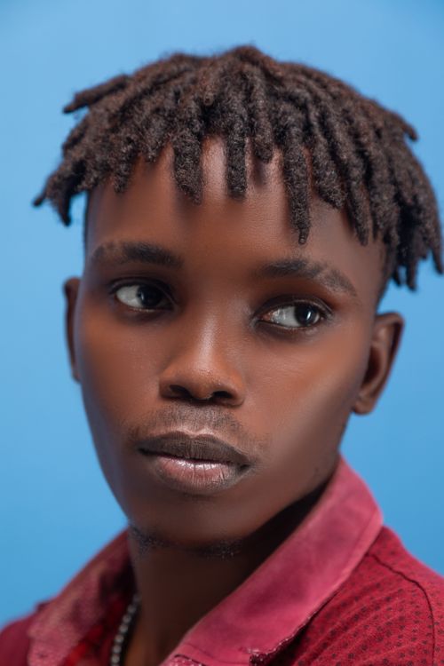 Free Close-up portrait of a stylish young black man against a blue background. Stock Photo