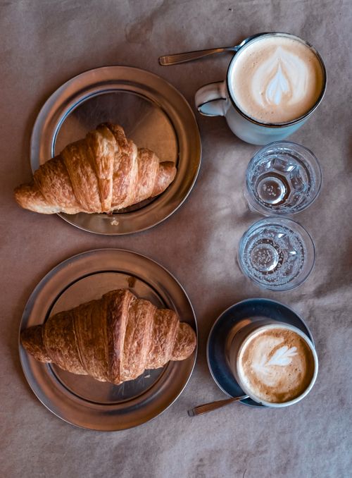Free Delightful café scene with croissants and cappuccinos, perfect for breakfast lovers. Stock Photo