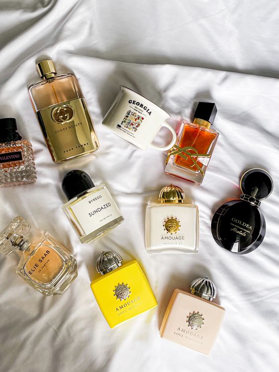 Flat lay élégant de plusieurs flacons de parfums de luxe féminins sur tissu doux