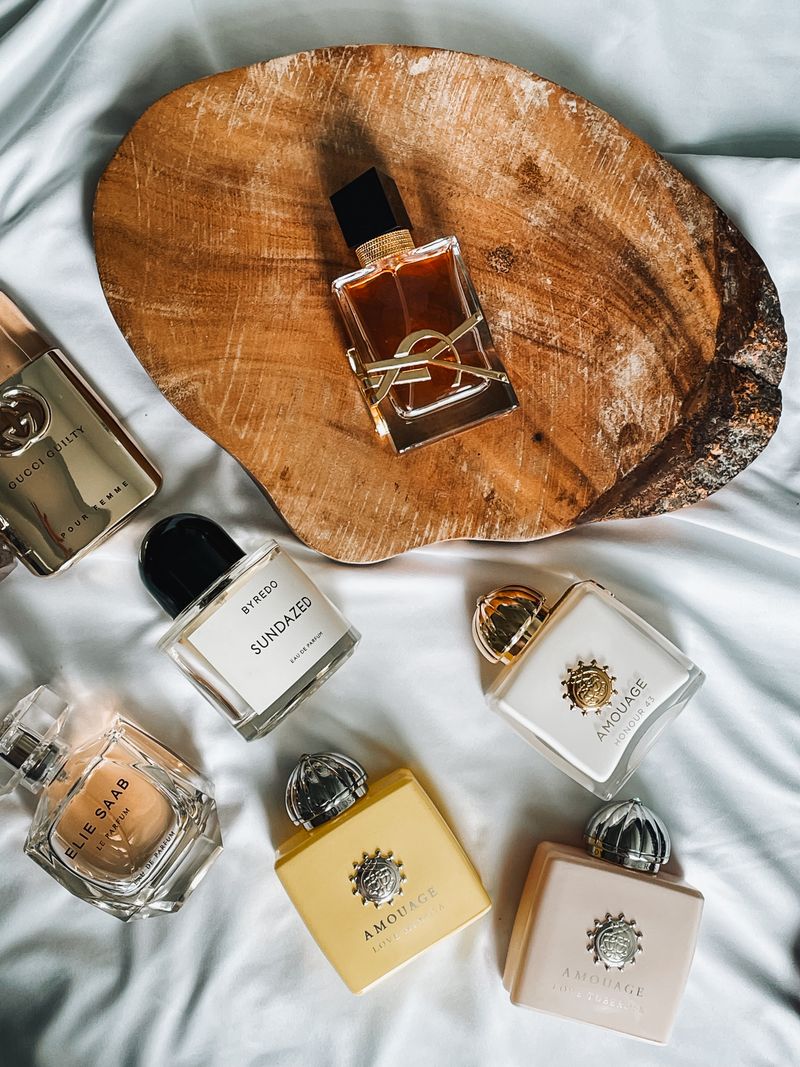 Flat lay of luxury perfume bottles on wood and fabric background