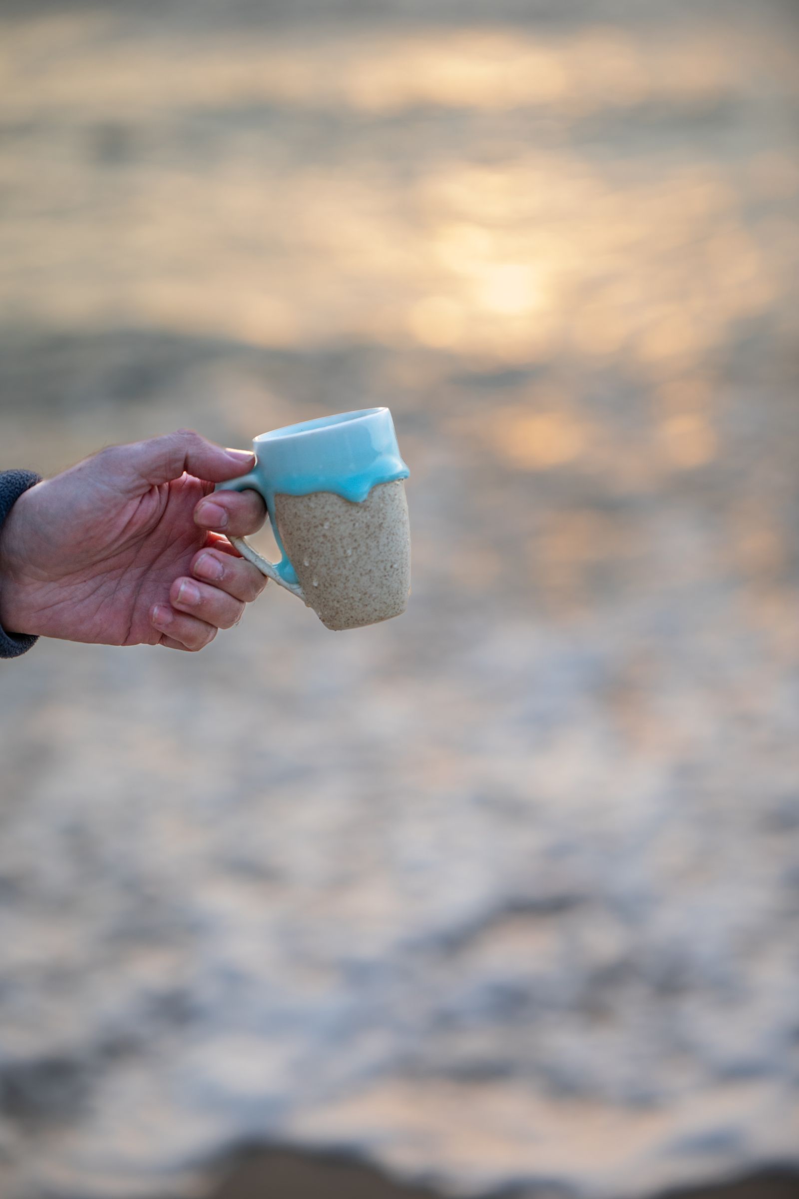 Coffee cup by the beach at sunrise