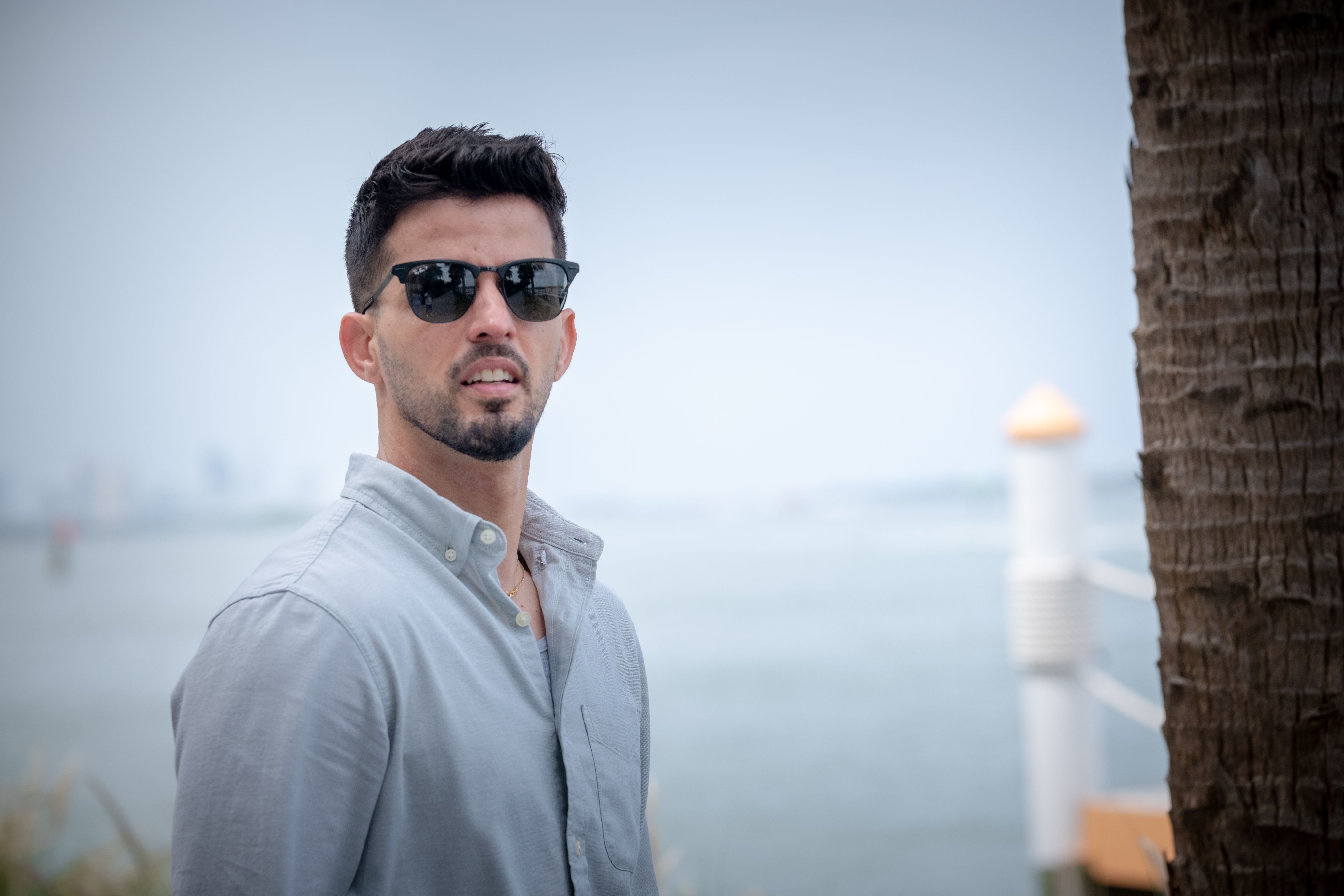 Man in Sunglasses by Waterfront Palm Tree · Free Stock Photo