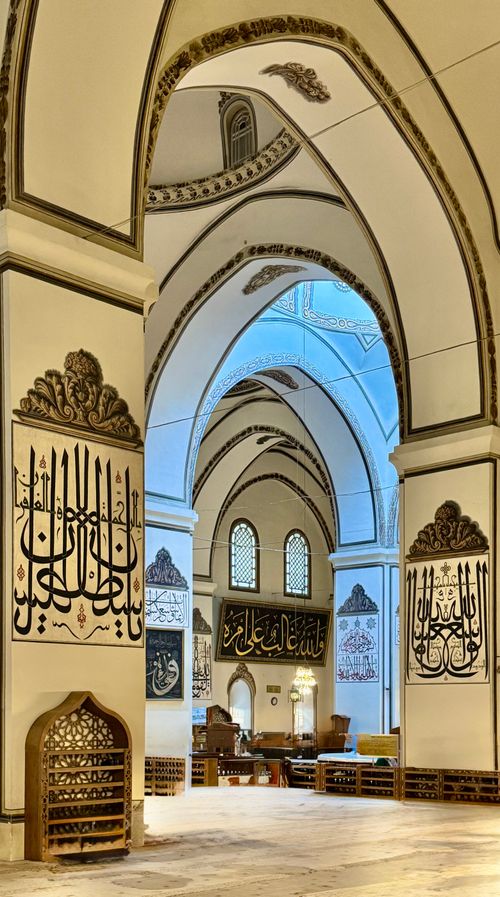 Free Elegant mosque interior with intricate arches and Islamic calligraphy. Stock Photo