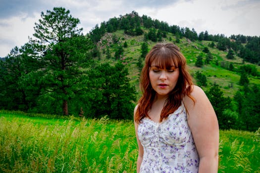 Portrait of a woman in a floral dress set against the picturesque Rocky Mountain backdrop, Boulder, Colorado.