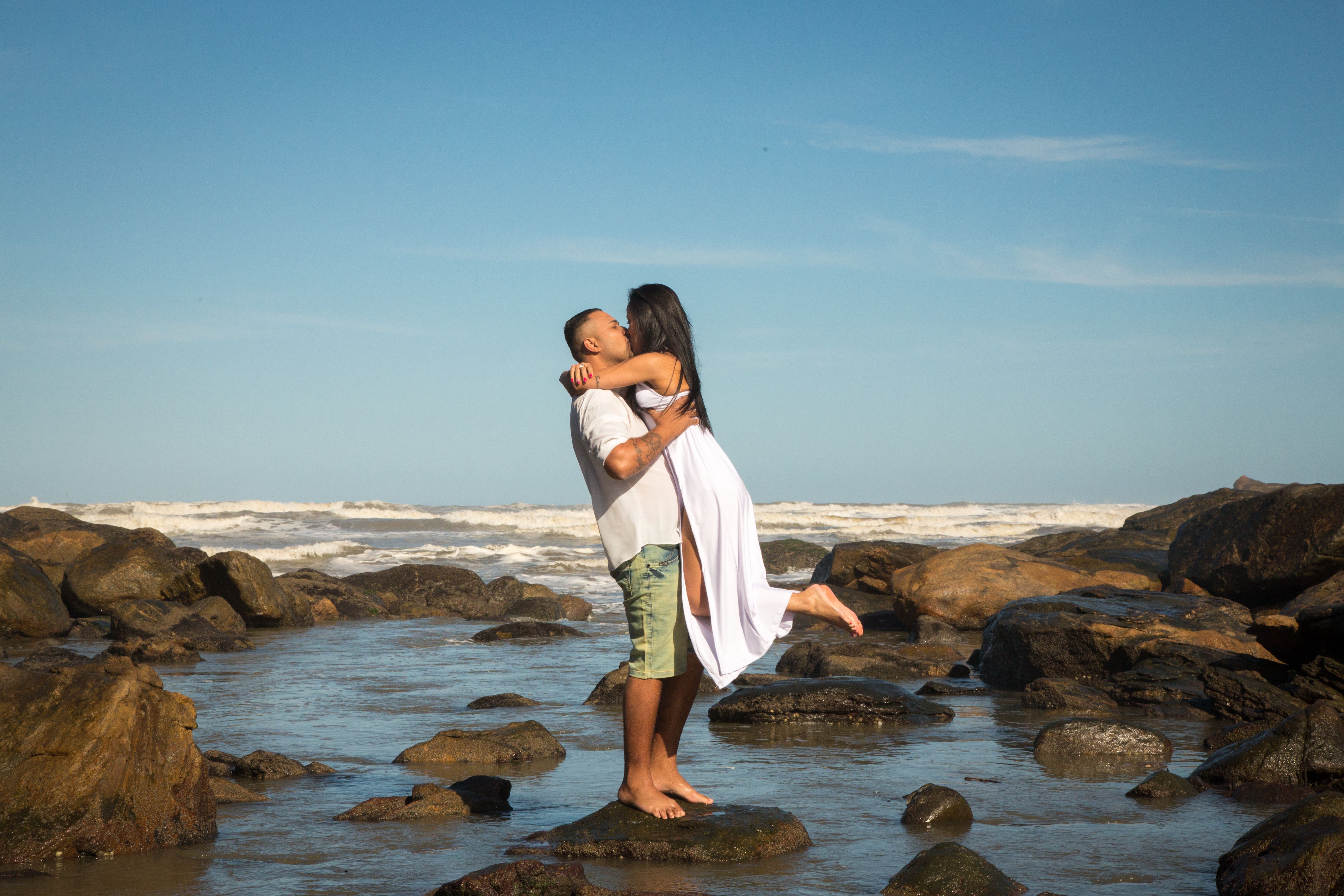Romantic Couple Embracing on a Rocky Beach · Free Stock Photo