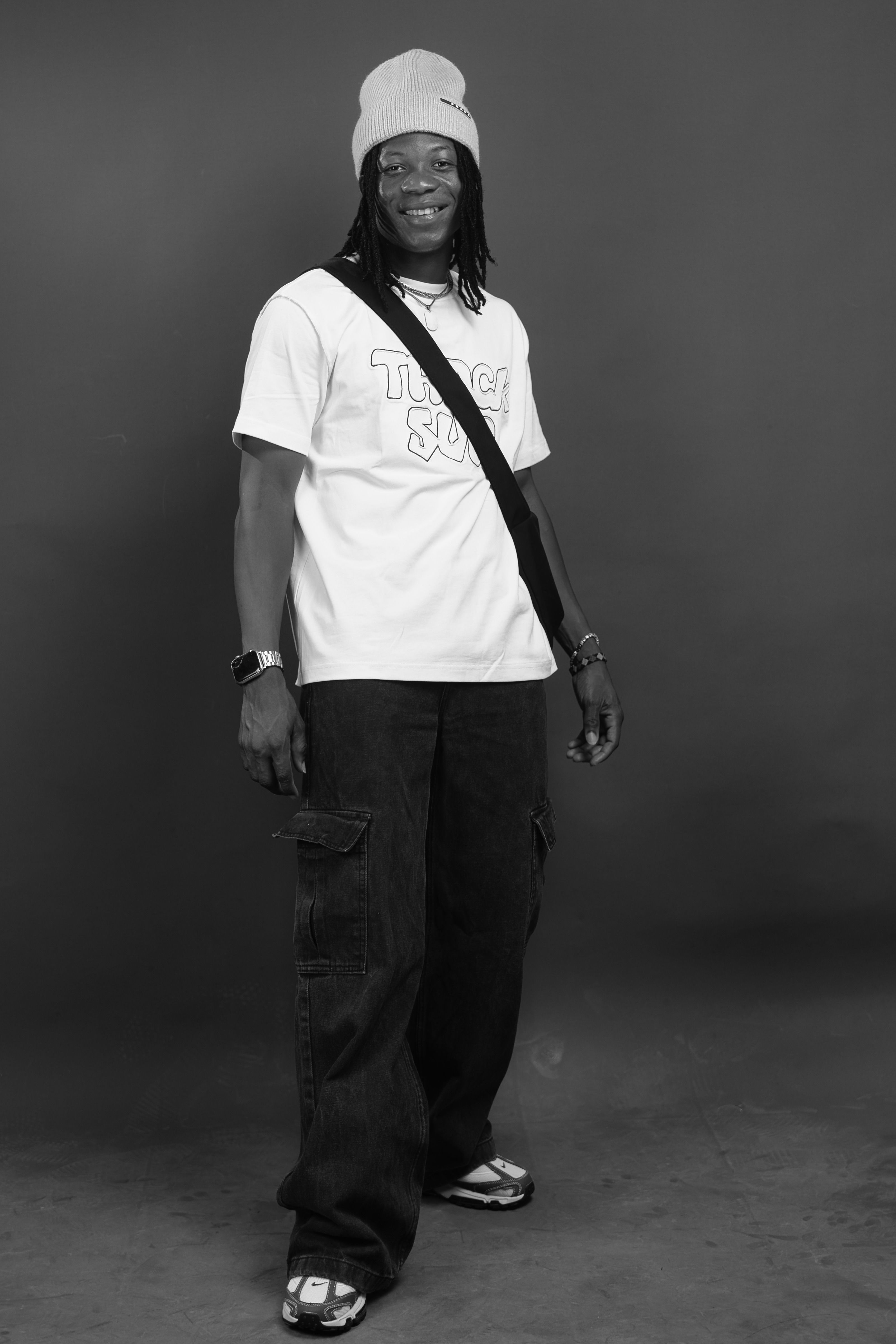 Casual black and white portrait of a stylish man wearing winter clothing and accessories.
