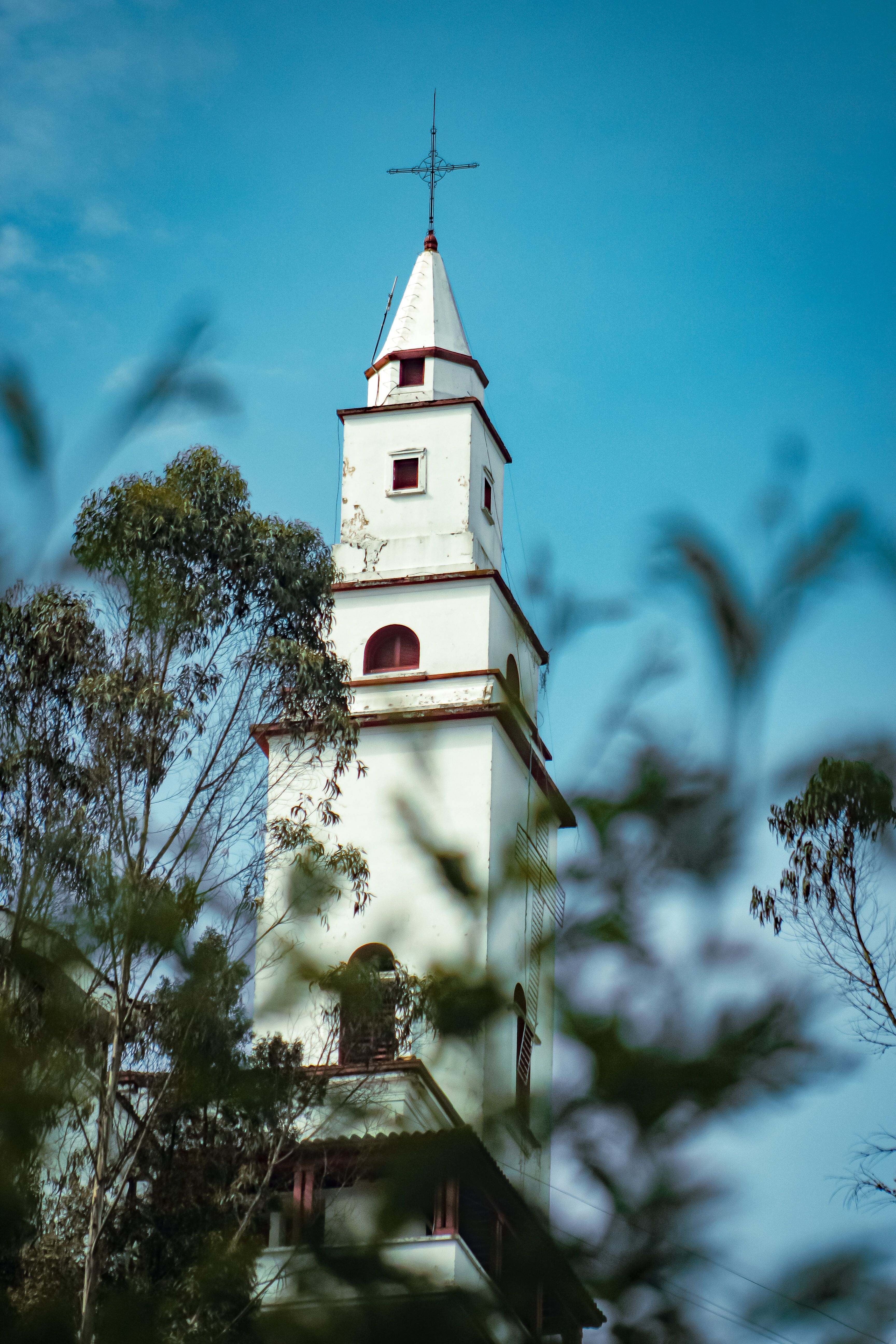White Church Tower Among Trees Under Blue Sky · Free Stock Photo