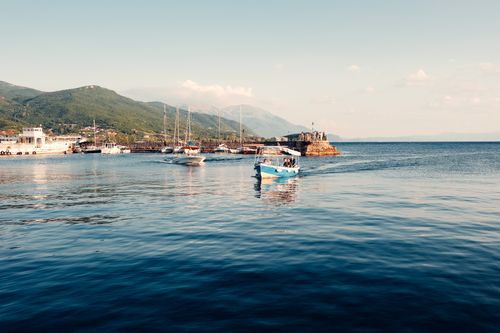 Free Picturesque boats sailing on Lake Ohrid with mountain backdrop in North Macedonia. Stock Photo