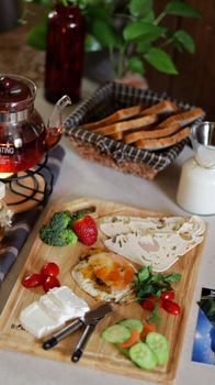 A vibrant breakfast spread featuring tea, eggs, vegetables, and toasted bread.