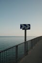 Seaside Walkway with Directional Sign and Ocean View