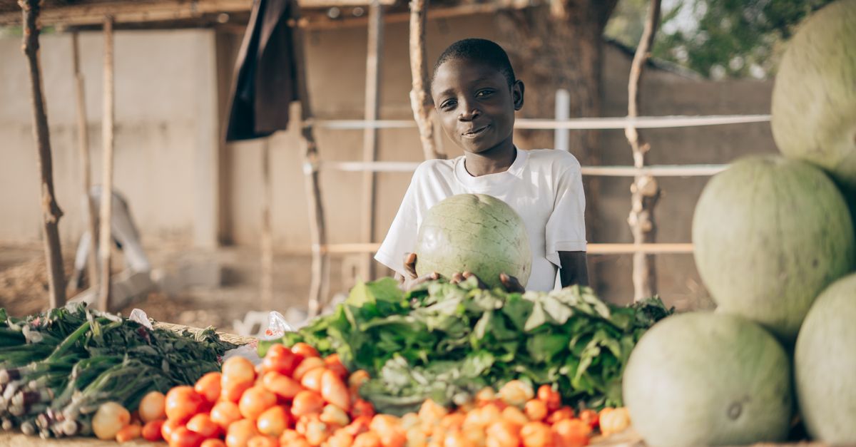 Local farmers in Ho Volta Region standing with fresh produce near a community market stall