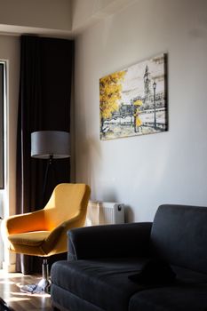 Modern living room featuring a yellow armchair, wall art, and soft lighting.