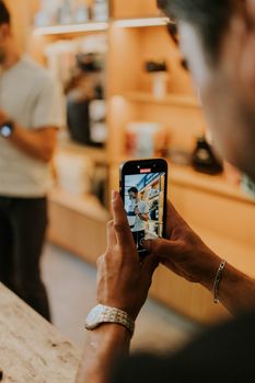 A person takes a photo inside a cafe, capturing a candid moment.