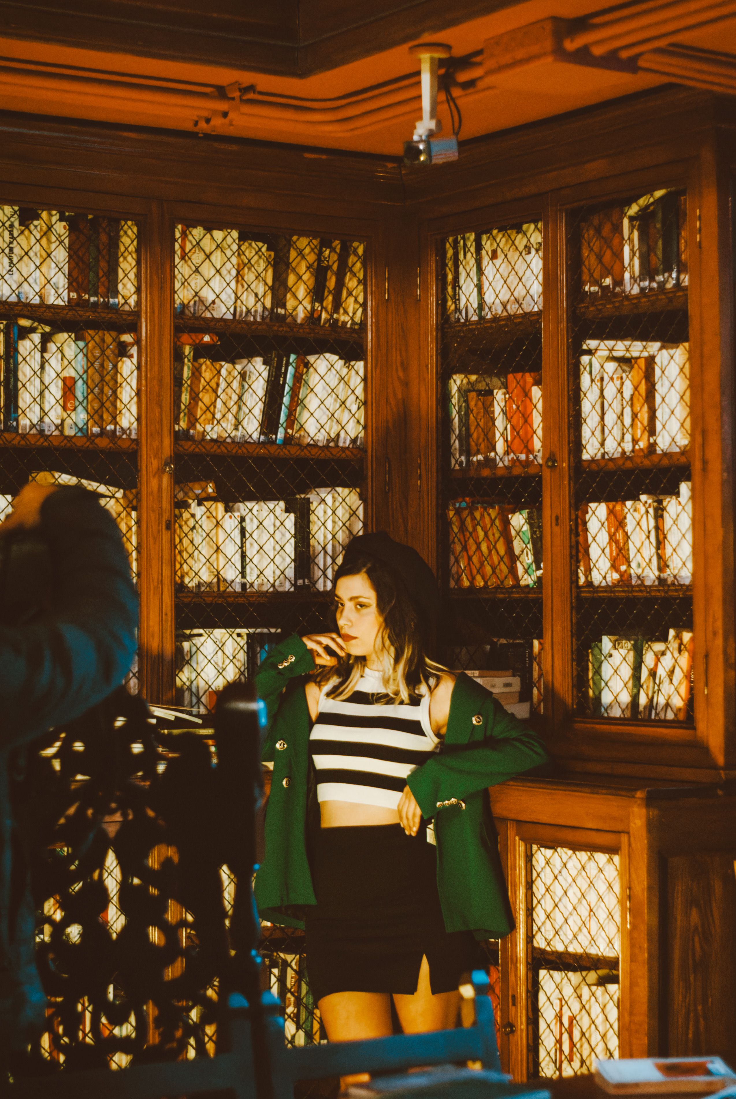 Young Woman Posing in Stylish Library Setting · Free Stock Photo