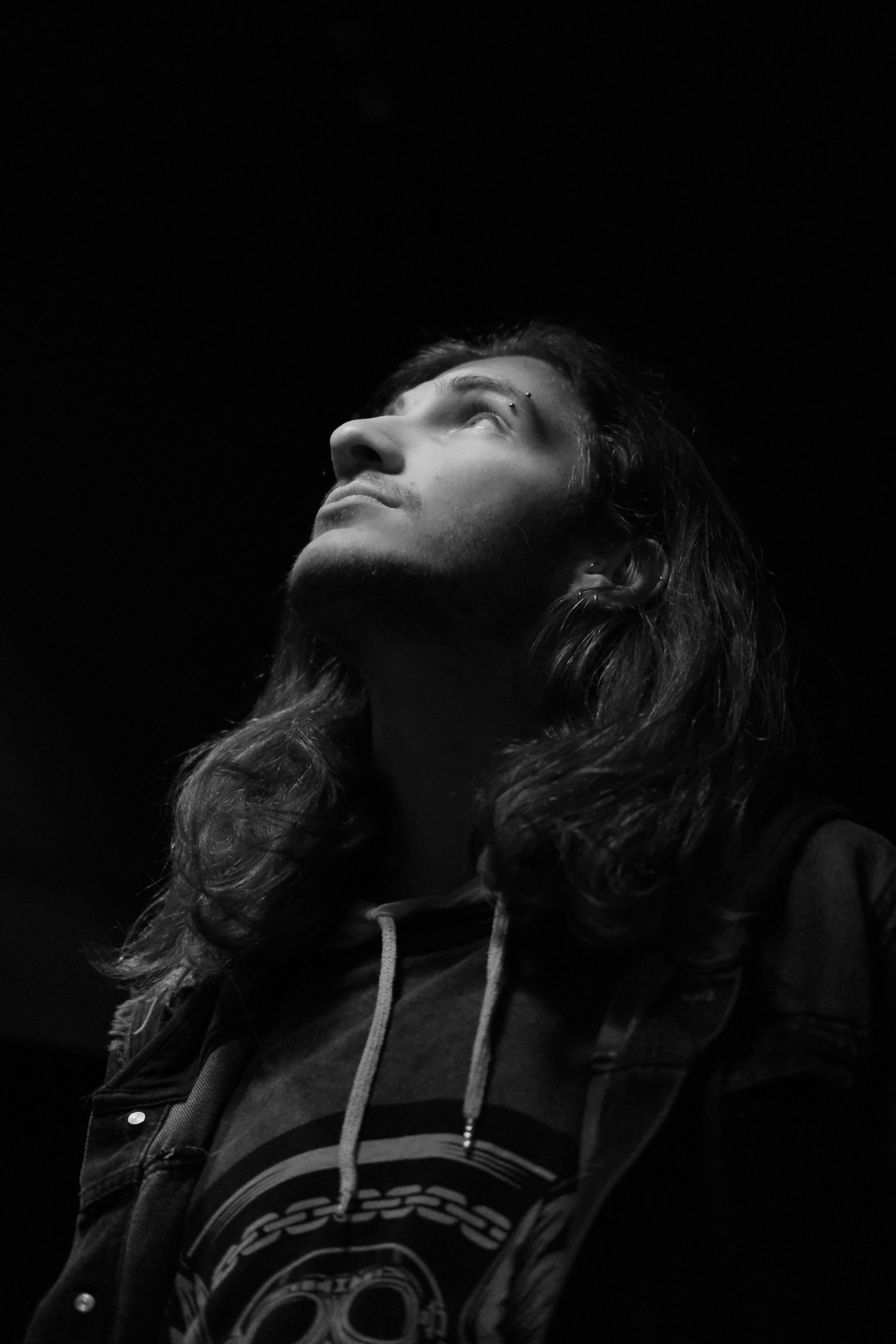 Moody black and white portrait of a man looking upward, highlighting expression.