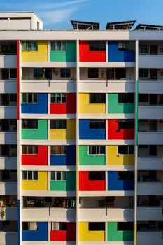 Vibrant facade of a multi-colored apartment building under daylight.