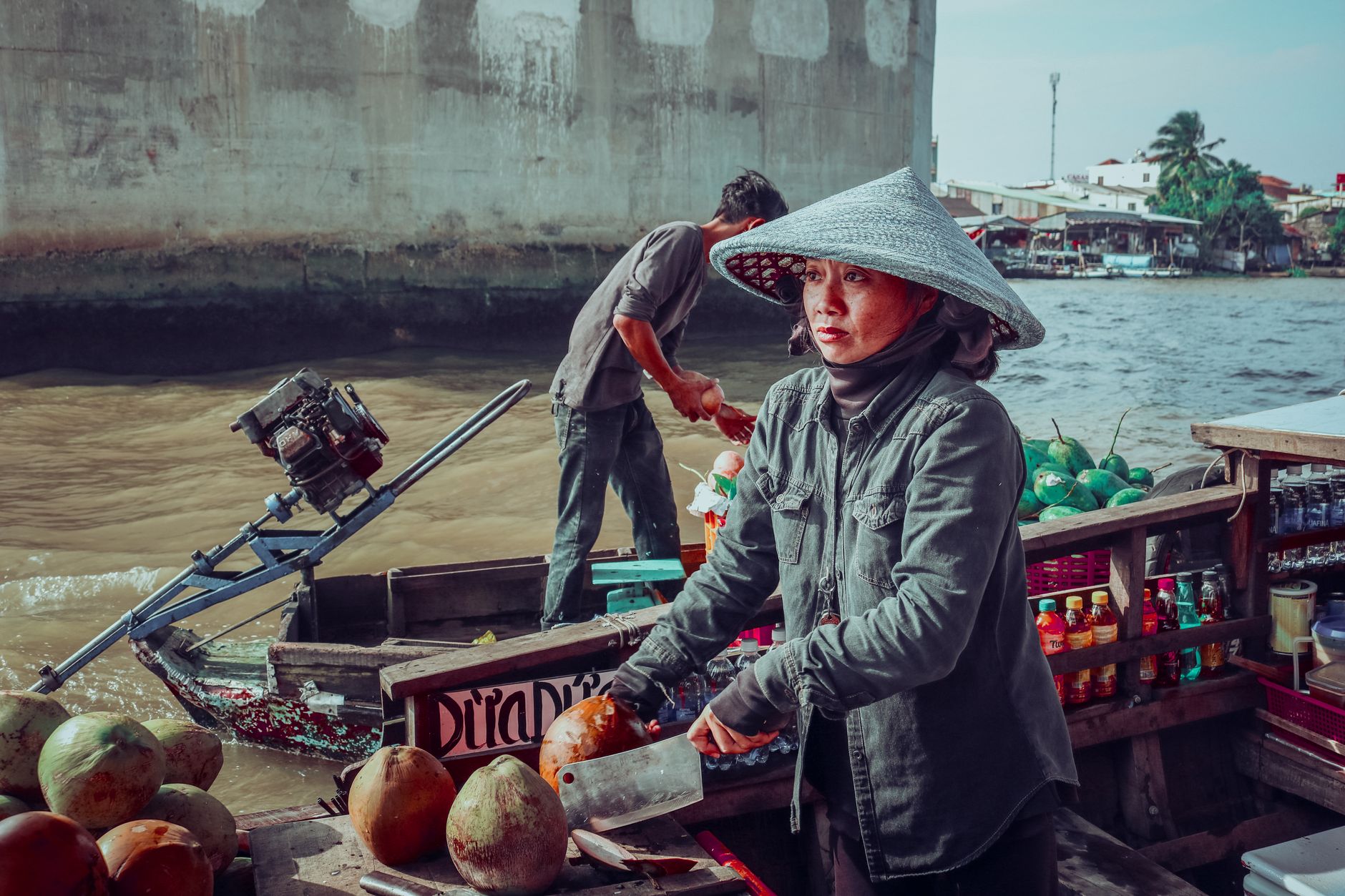 Vietnamese vendors selling coconuts on a floating market boat.
