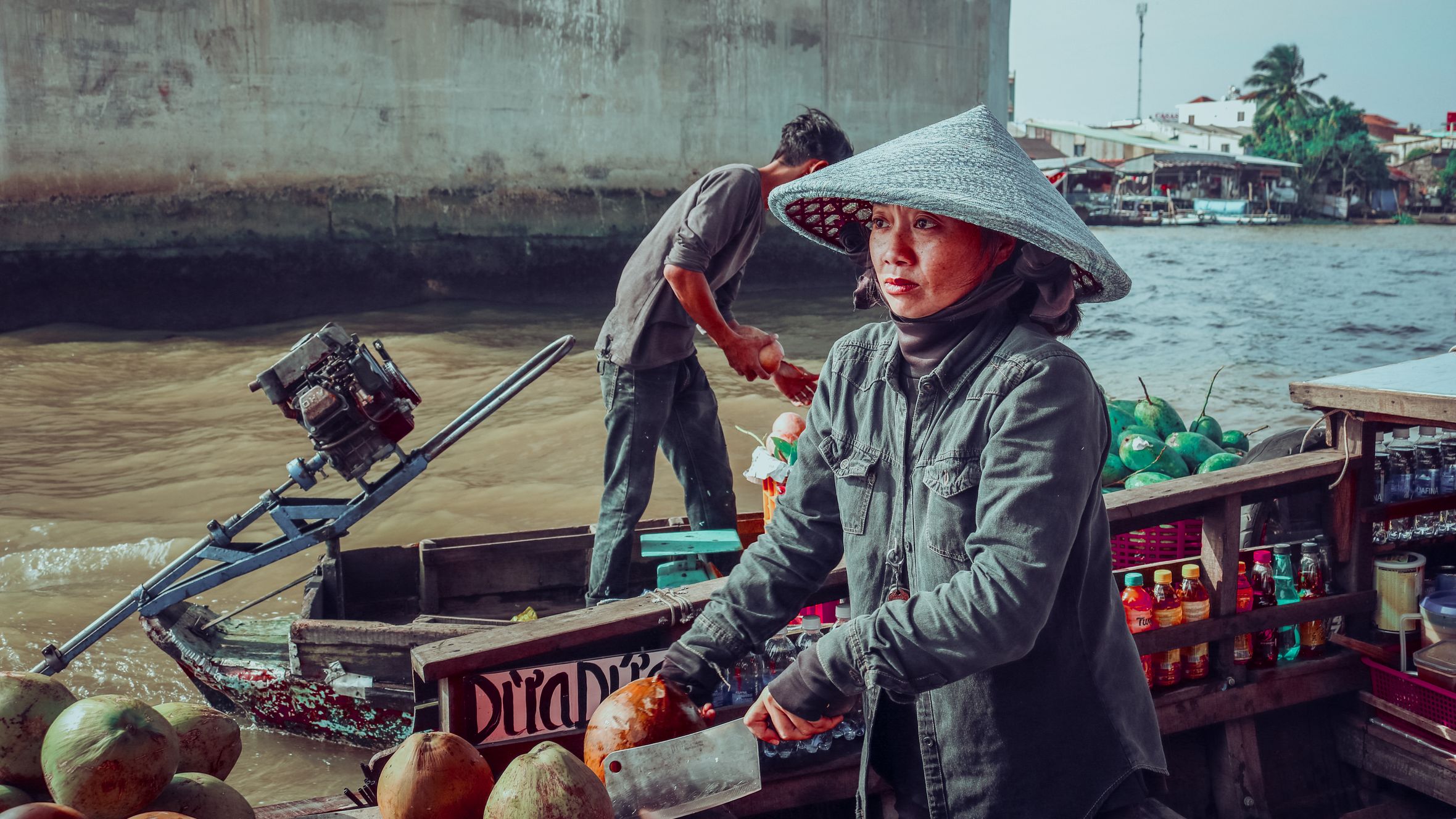 Vietnamese vendors selling coconuts on a floating market boat.