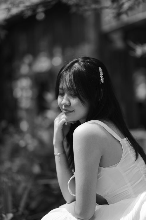 Free Black and white portrait of a woman in a serene outdoor setting, reflecting elegance. Stock Photo