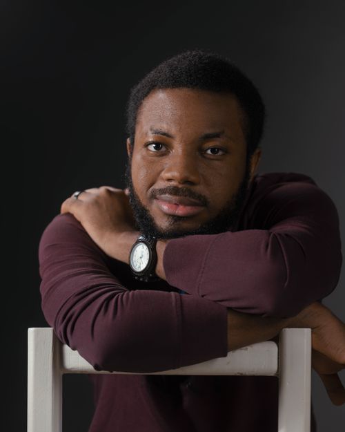 Free Intimate portrait of a thoughtful young man with arms resting on a chair. Stock Photo