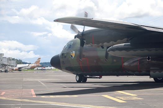 C130 Hercules military aircraft on a sunny day at Sulawesi Utara airport.