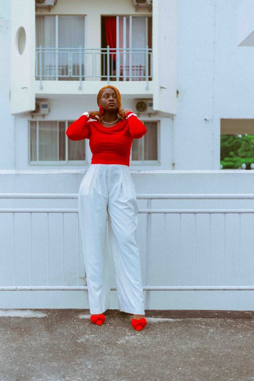 Free Elegant woman in afrocentric fashion posing outdoors in red and white attire. Stock Photo