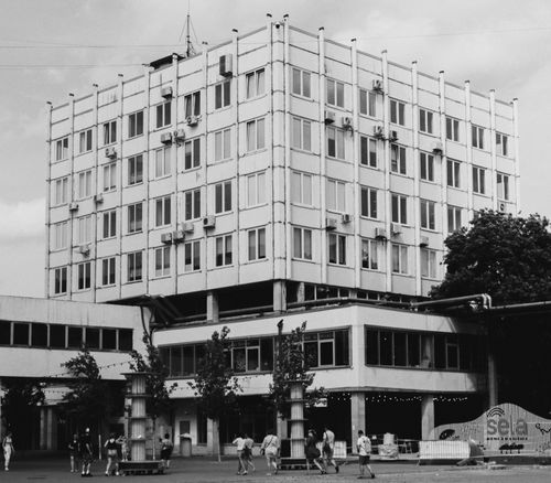 Free Black and white photo of a modernist building with people walking nearby, highlighting urban architecture. Stock Photo