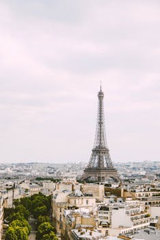 A stunning view of the Eiffel Tower amid Parisian architecture on a cloudy day.