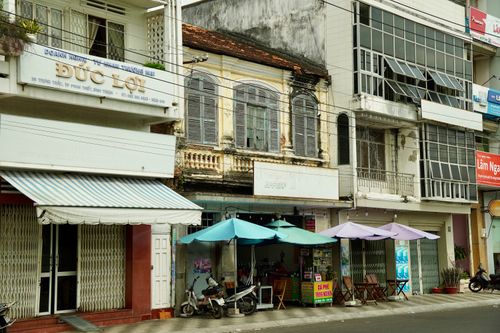 Free A vibrant street scene in Phan Thiet, Vietnam featuring outdoor cafés and historic architecture. Stock Photo