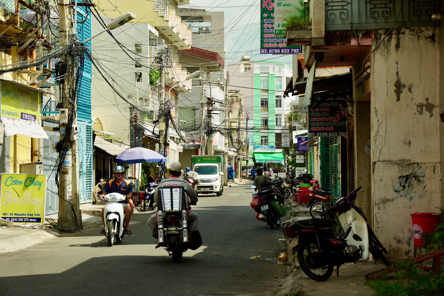 Motorcycles and signs fill a lively street in urban Vietnam, showcasing daily life.
