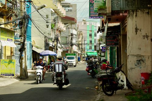 Free Motorcycles and signs fill a lively street in urban Vietnam, showcasing daily life. Stock Photo