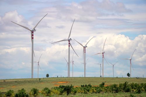 Free A scenic landscape featuring multiple wind turbines against a cloudy sky, symbolizing renewable energy. Stock Photo