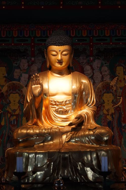 Free Golden statue of Buddha in a meditative pose within a temple setting, highlighting spiritual calm. Stock Photo