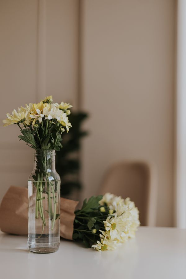 Elegantes flores amarelas em um vaso de vidro, perfeitas para decoração de interiores minimalista e moderna.