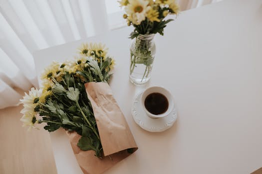 A bright morning scene with coffee and daisies on a white table, creating a fresh vibe.