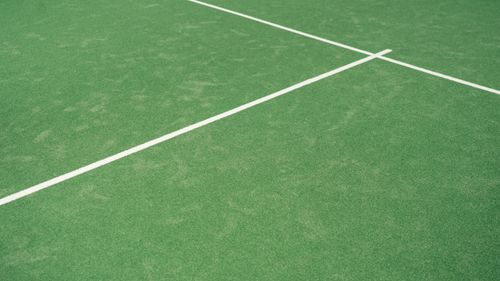 Free Close-up view of tennis court's vibrant green surface with white lines Stock Photo