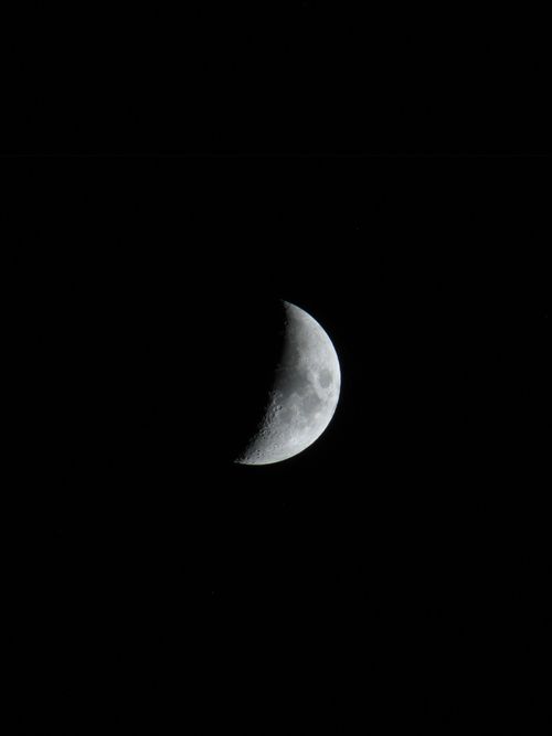 Free Captivating crescent moon shining bright against a dark, starless night sky. Stock Photo