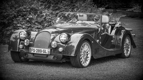 Free Classic convertible car with driver in a black and white setting. Stock Photo