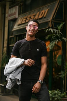 一位穿着休闲装的时尚男士在户外自信地摆出姿势，散发着魅力与时尚气息